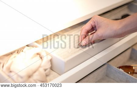 Female Hand Choosing The Ring From The Jewelry Box That Decorated In The Built-in Wardrope In The Be