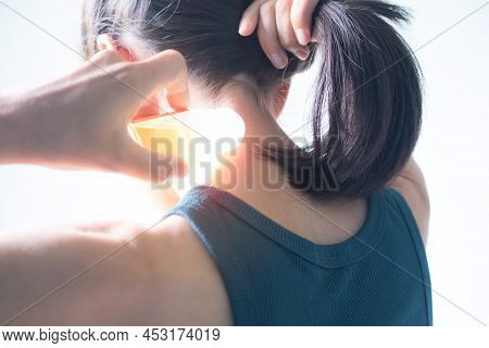 Overlight On Woman Holding Balm On Neck. She Neck Pain Due To Strenuous Exercise.generic Home Remedi