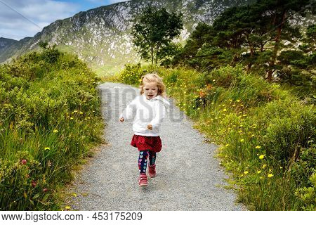 Cute Little Happy Toddler Girl Running On Nature Path In Glenveagh National Park In Ireland. Smiling
