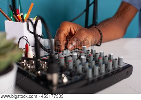 Closeup Of Content Creator Hand Adjusting Master Volume Fader On Mixer Console On Desk During Live P