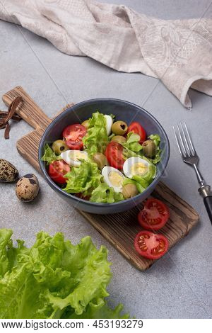 Healthy Salad With Fresh Lettuce, Cherry Tomatoes, Quail Egg And Olives In Bowl