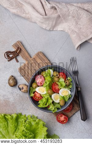 Healthy Salad With Fresh Lettuce, Cherry Tomatoes, Quail Egg And Olives