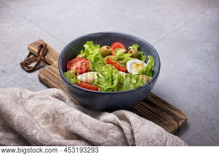 Healthy Salad With Fresh Lettuce, Cherry Tomatoes, Quail Egg And Olives In Bowl