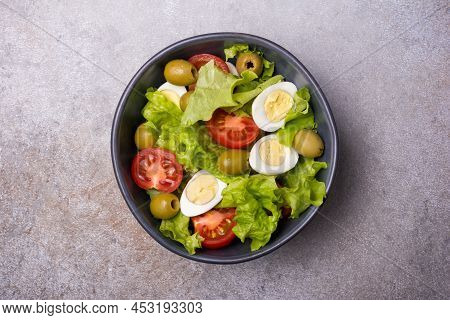 Healthy Salad With Fresh Lettuce, Cherry Tomatoes, Quail Egg And Olives In Bowl