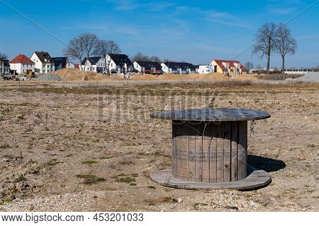 Large Wooden Reel Without Cable Wire Outdoor. Housing On Background.