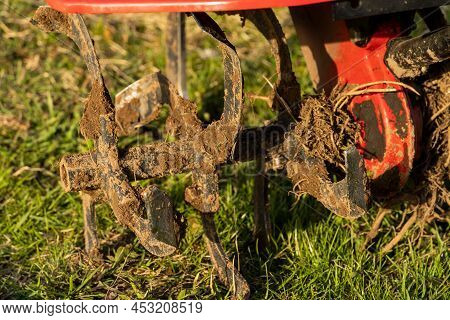 Dirty Cultivator Blades Close-up. Tilling The Land On The Farm. Farming.