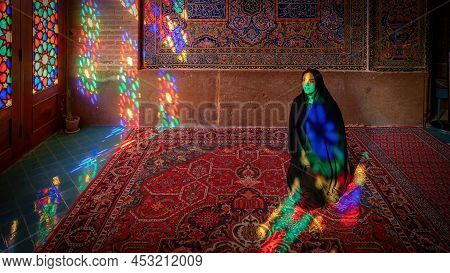 Iran, Shiraz - May 2019: Iranian Woman Inside With Stained Glass Window Reflections Of Nasir Al-mulk