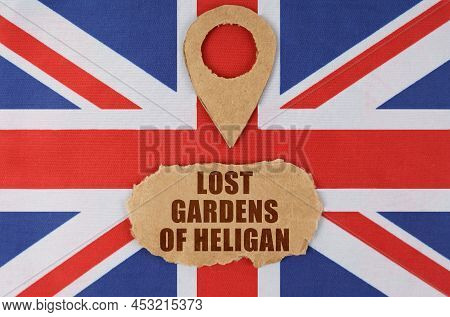 Travel Concept. On The Flag Of Great Britain Lies A Symbol Of Geolocation And Cardboard With The Ins