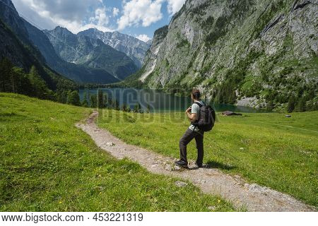 Man With Backpack On Hiking Trail Enjoying Hinterer Gosausee, Salzkammergut. Austria