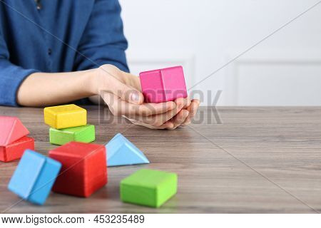 Aba Therapist With Colorful Building Blocks At Wooden Table, Closeup