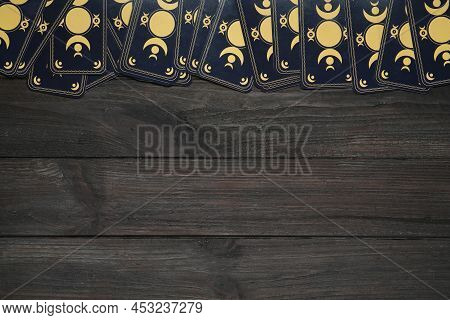 Tarot Cards On Black Wooden Table, Flat Lay With Space For Text. Reverse Side