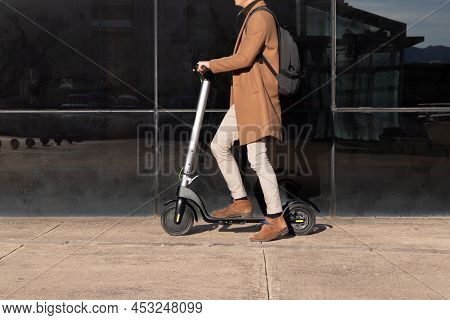 Unrecognizable Businessman On Daily Commute Riding Micro Scooter Whearing An Elegant And Modern Outf