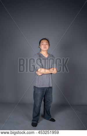 Asian Long Hair Friendly And Positive Man Is Posting And Standing In Front Of Gray Background With S