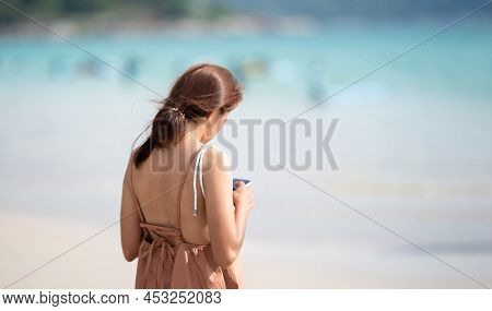 The Shoulder Of Asian Thai Woman From Backside Who Play Mobile At Outdoor Field Sea Beach Blur Backg