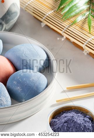 A Bowl Of Japanese Mochi With Chopsticks And Wooden Mat On White Countertop. Concept Of A Traditiona