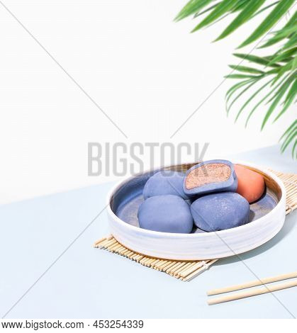 Concept Of A Traditional Japanese Dessert On A Blue Table. A Plate Of Japanese Mochi With Chopsticks