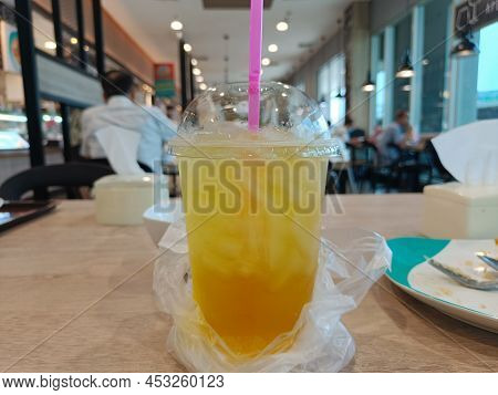 Iced Chrysanthemum Juice On Wood Table In Blurred Cafe Restaurant