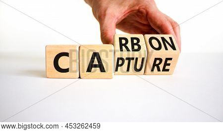 Carbon Capture Symbol. Businessman Turns Wooden Cubes And Changes The Concept Word Carbon To Capture