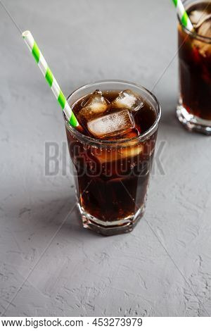 Cold Refreshing Dark Cola With Ice Cubes On A Gray Background, Side View.