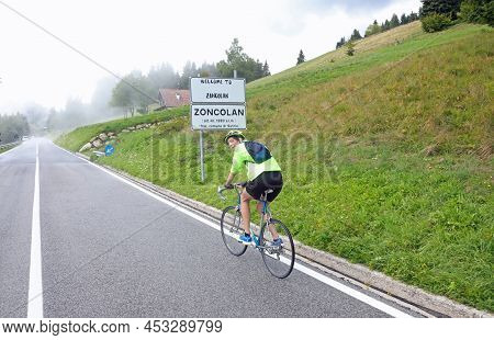 Young Cyclist Riding His Racing Bike On Monte Zoncolan In Northern Italy On A Very Foggy Day