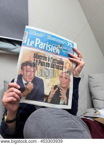 Paris, France - Apr 21, 2022: Woman Reading On The Living Room Couch Le Parisien Newspaper After Deb
