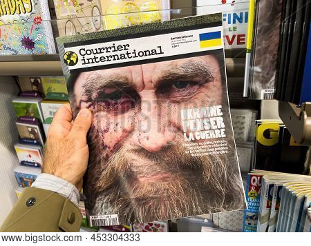 Paris, France - Apr 11, 2022: Man Buys At Press Kiosk Courrier International Newspaper Magazine With