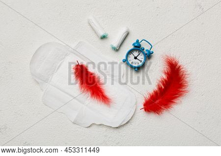 Ringing Alarm Clock With Sanitary Female Tampons And Menstrual Sanitary Pads. Medical Concept Of Wom