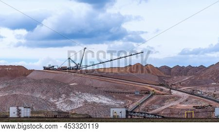 Giant Spreader Or Absetzer Machinery. A Large Dumper On A Landfill With Potash Ore. Extracting Potas