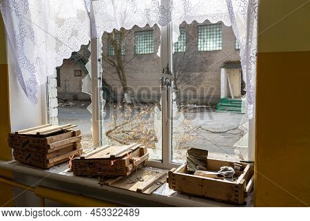 Barmashovo, Ukraine- March 18, 2022: Trash, Garbage And Wooden Boxes With Weapons In The Half-destro