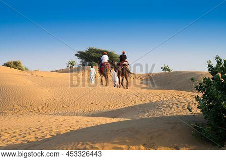 Tourists Riding Camels, Camelus Dromedarius, At Sand Dunes Of Thar Desert. Camel Riding Is A Favouri