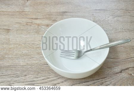 White Bowl With Silver Fork On Table