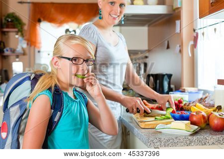 Anne sabah ve bir aperatif için okul çocukları için kahvaltı yapmak