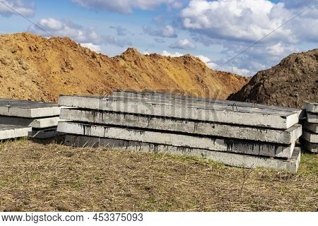 Reinforced Concrete Slabs At A Construction Site Against A Blue Cloudy Sky And Earth. Folded Plates 