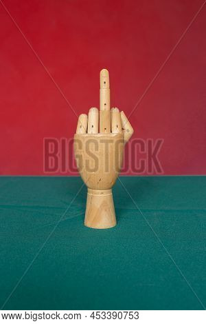 Wooden Hand With Middle Finger On Red-green Background