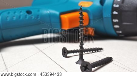 Screwdriver And Screws Lie On A Sheet Of Drywall. The Gypsum Sheet Is Marked With A Pencil. Building