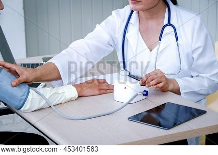 Health Care Concepts : The Doctor Uses A Blood Pressure Monitor To Measure The Hypertension Of A Fem
