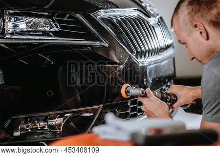 Auto Mechanic Worker Polishing Car At Automobile Repair And Renew Service Station Shop By Power Buff