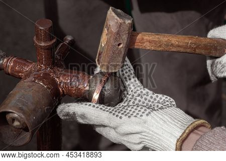 Master With A Hammer Performs Stamping Or Engraving Of A Decorative Pattern On A Metal Plate