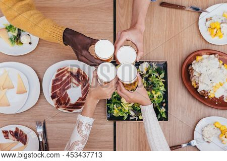 Aerial View Of A Beer Toast Between 4 Friends Of Different Ethnicities
