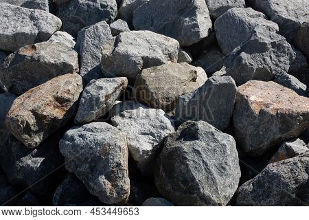 Large Grey Rough Rocks Piled On The Beach. Granite Stones Backdrop