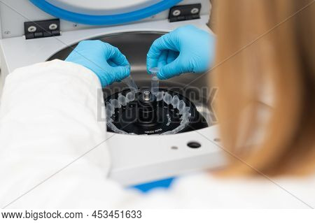Laboratory Worker Puts Chemical Tubes Into The Centrifuge. Biochemistry And Research Laboratory Conc