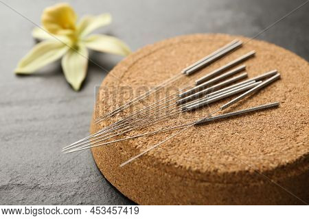 Cork Coaster With Acupuncture Needles On Black Table, Closeup
