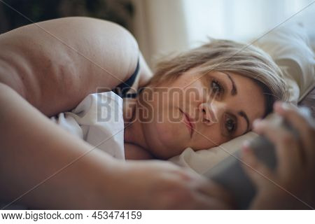 Depressed Lonely Fat Woman Lying In Bed At Home And Thinking.