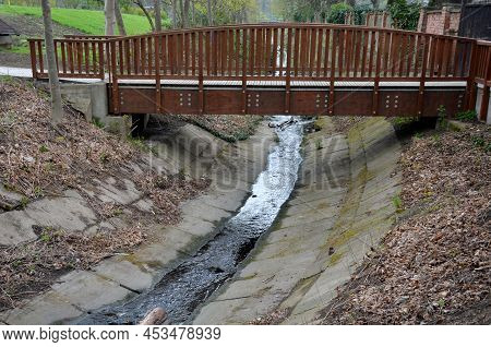 Pedestrian Bridge Over A Small Gorge And A Stream. Consists Of Two Steel Crossbars. Because  Surface