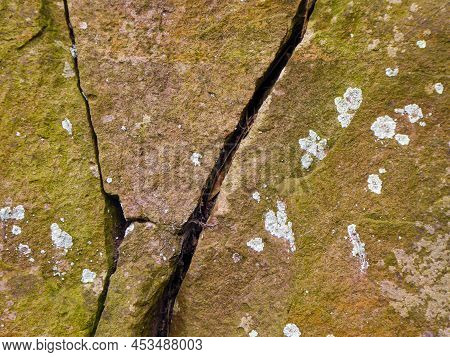 Close Up Of Weathered Sandstone Rock With Mosses, Lichens And Cracks In Rock