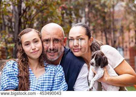 Young Family Outdoors With Their New Born Puppies In A Sunny Day