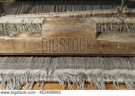 The Machine Is A Hand-made Wooden Loom With Threads For Working On The Machine. An Old Loom