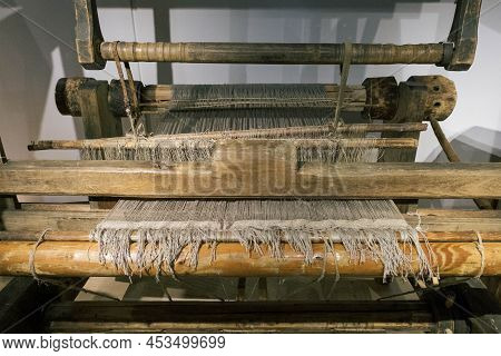 The Machine Is A Hand-made Wooden Loom With Threads For Working On The Machine. An Old Loom