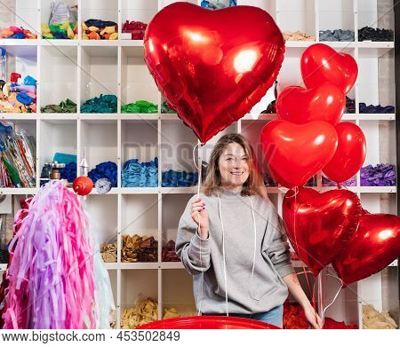 Woman With A Large Red Ball Of Foil In The Shape Of Heart.