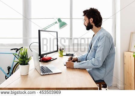 Professional Young Creative Designer Using Digital Graphic Tablet And Laptop Computer With White Bla